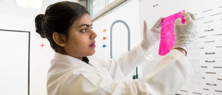 Female scientist looking at dye <p>Anuradhi Liyanapathiranage inspects a dyed textile. (Nancy Evelyn/UGA)</p>