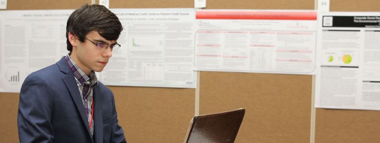 Man in suit at computer <p>FHCE graduate Ben Jacobs researched financial literacy, savings behavior and risk tolerance of college students.</p>