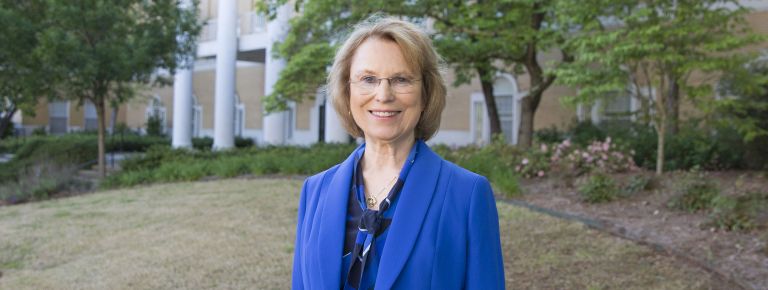 Lynn Bailey in front of Dawson Hall