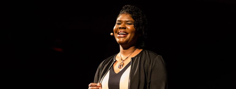 Woman standing on TED Talk stage