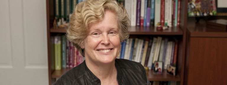 Photo of woman (Margaret Caughy) in front of bookcase