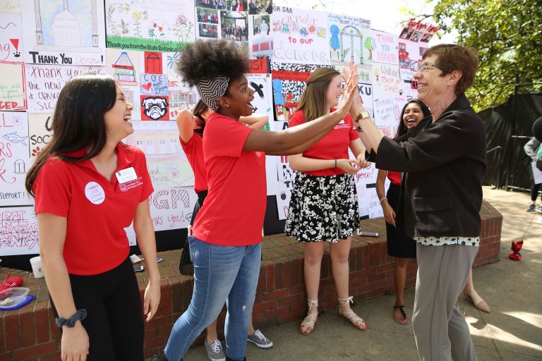 Dean Fox with students giving high 5's 