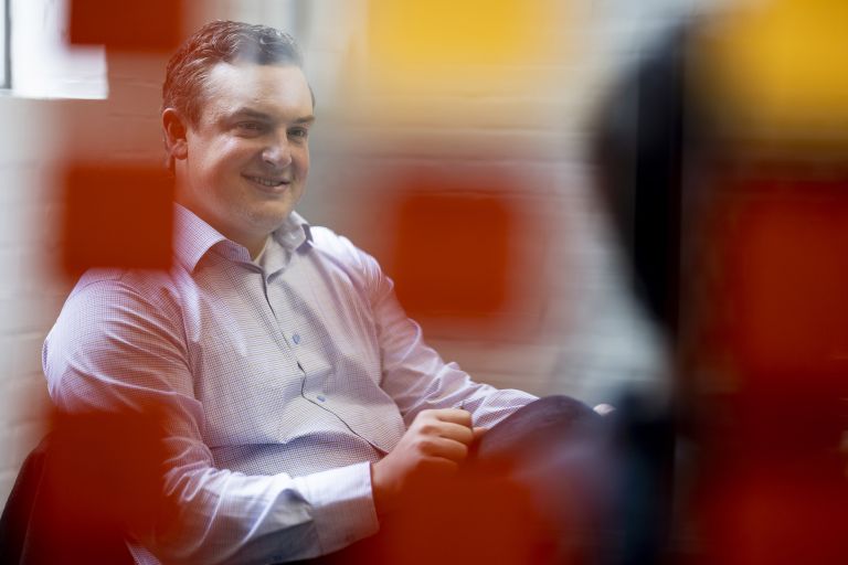 Man sitting behind colored glass