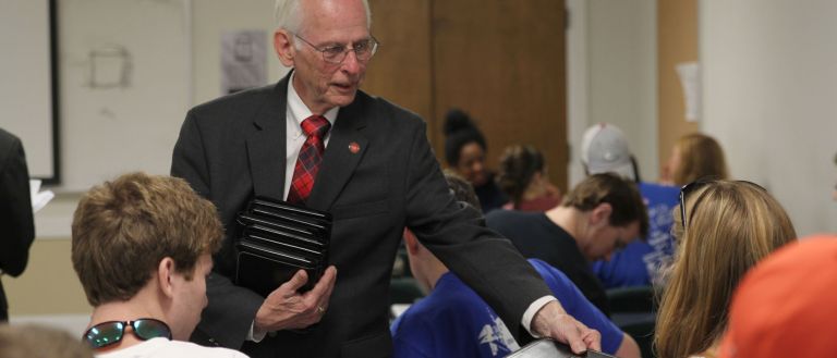 Photo of man in a suit in a classroom 