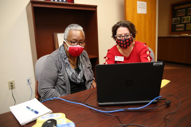 Two women behind laptop